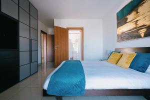 a bedroom with a large bed with blue pillows at Sunny 2 BR Aptm with Garden Fast WiFi Walk to Seafront in Il-Gżira +20 photos