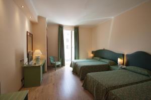Una habitación de hotel con dos camas y una ventana. en Hotel Laurentia, en Roma