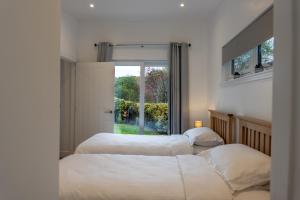 two beds in a bedroom with a window at The Chalet at Wyvis in Spean Bridge