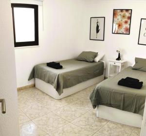 Un dormitorio con dos camas y una ventana. en Los Juncos 401 Maspalomas, en Playa del Inglés 19 fotos más