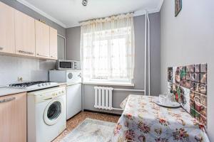 eine kleine Küche mit einer Waschmaschine und einem Tisch in der Unterkunft Комфортные апартаменты в центре города, Евро однушка #19 in Almaty
