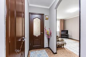 einen Flur mit einer Tür mit einer Blumenvase in der Unterkunft Комфортные апартаменты в центре города, Евро однушка #19 in Almaty