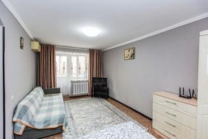 ein Wohnzimmer mit Sofa und Fernseher in der Unterkunft Комфортные апартаменты в центре города, Евро однушка #19 in Almaty