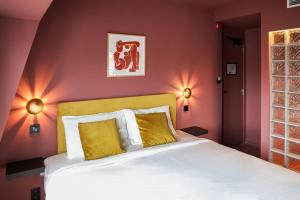 a bedroom with a bed and two lights on the wall at The Mila Brussels in Brussels