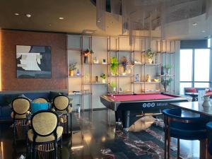 a room with a pool table and some chairs at Edge Central Pattaya By Su in Pattaya