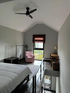 a bedroom with a bed and a pink chair at The Loft Junction in Funchal