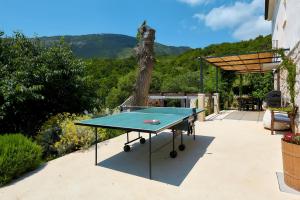 a ping pong table sitting on a patio at Villa Eugenia for 8 people with private pool & large garden only 3 km from the beach in Mošćenička Draga