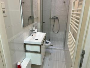 Un baño con inodoro, lavabo y ducha. en Dave Apartman 3, en Szeged