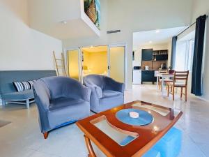シドニーにあるKozyGuru Summer Hill 1 Bed TownHouseの椅子2脚とテーブルのあるリビングルーム