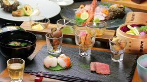 a table topped with glasses of food and sushi at 旅館かつみや Katsumiya in Nago +26 photos