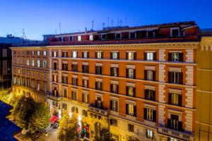 a large orange building in a city at night at Hotel Oxford in Rome