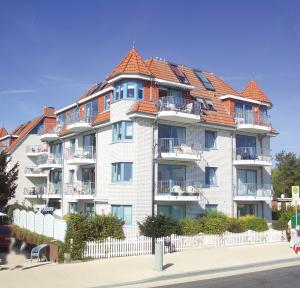 a large white building with an orange roof at Strandschlößchen Strandschlösschen Appartement 5 in Haffkrug