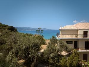 una casa en una colina con el océano en el fondo en Rosa Sea Front Maisonette, en Alikanas