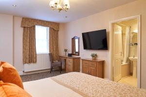 a bedroom with a bed and a flat screen tv at Kingston Theatre Hotel in Hull