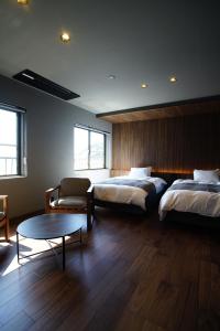 a hotel room with two beds and a coffee table at 旅館かつみや Katsumiya in Nago