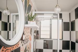 a bathroom with black and white tiles and a mirror at No 1 Dicks Street Apartment in Howick +72 photos
