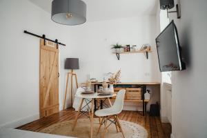a dining room with a table and a tv at I Gemütliches 1-Zimmer-Apartment & eigenes Bad I in Neuendorf