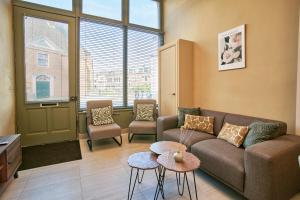 a living room with a couch and two chairs at Seaside design apartment in Scheveningen