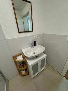 a white bathroom with a sink and a mirror at Neues Apartment Ehingen 2.0 in Ehingen