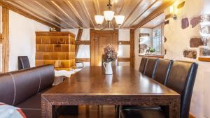 une salle à manger avec une table en bois et des fauteuils en cuir dans l'établissement Schwarzwald - Ferienhaus In, à Villingen-Schwenningen