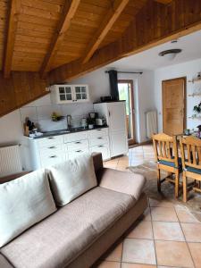 a living room with a couch and a kitchen at Ferienwohnung Fleur in Bad Kohlgrub