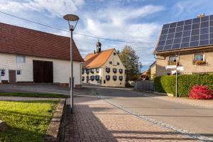 une rue éclairée par un lampadaire et un bâtiment équipé de panneaux solaires dans l'établissement Schwarzwald - Ferienhaus In, à Villingen-Schwenningen