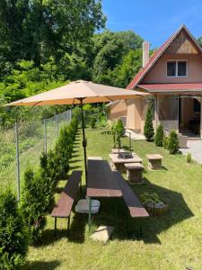 a picnic table and an umbrella in a yard at Molla Villa Kökény in Kökény