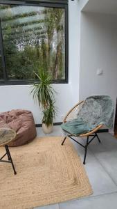 two chairs and a rug in a room with a window at Maison de campagne au bord du ruisseau-5mn mer in Lamballe Armor +21 photos
