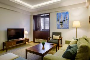 a living room with a couch and a tv at Boutique Residence Iconia-Lemon Spaces Zamalek in Cairo