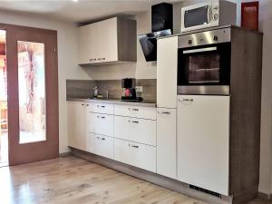 プルークガーンにあるApartment Kulmer Hof by Interhomeの白いキャビネットと電子レンジを備えたキッチン