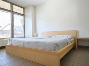 a bedroom with a wooden bed with a large window at Apartment Čertovka-2 by Interhome in Harrachov