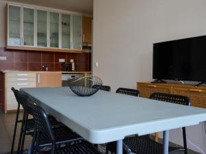 a room with a table with chairs and a tv at Apartment Čertovka-2 by Interhome in Harrachov