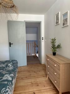 a bedroom with a bed and a dresser with a plant at Maison cosy rénovée, proche de Carcassonne in Villarzel-Cabardès