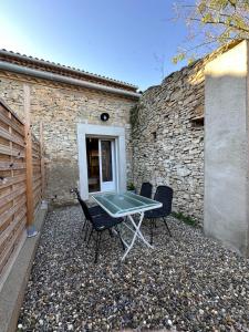 a patio with a table and chairs in front of a building at Maison cosy rénovée, proche de Carcassonne in Villarzel-Cabardès