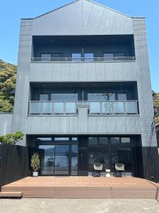 a tall building with two chairs in front of it at 旅館かつみや Katsumiya in Nago