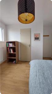 a bedroom with a bed and a book shelf at Chambre avec Salle d'eau privée in Vitré