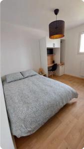 a bedroom with a bed and a desk in it at Chambre avec Salle d'eau privée in Vitré