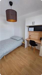 a small bedroom with a bed and a desk at Chambre avec Salle d'eau privée in Vitré