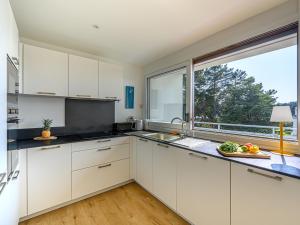 a kitchen with white cabinets and a large window at Apartment Men Er Bellec-3 by Interhome in Saint-Philibert