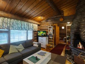 ein Wohnzimmer mit Couch und Kamin in der Unterkunft Holiday Home Kaukonkelo by Interhome in Rukatunturi 