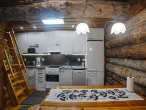 eine Küche mit weißen Schränken und einem Herd mit Backofen in der Unterkunft Holiday Home Kaukonkelo by Interhome in Rukatunturi 