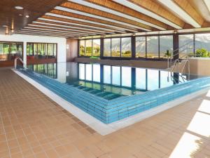 a large swimming pool in a building with windows at Apartment Terrasse des Alpes 2006 by Interhome in Crans-Montana