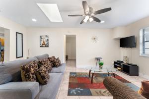 Una sala de estar con un sofá y un ventilador de techo. en Spacious 5BR Home with Pool, Near Downtown & Beach, en Hollywood