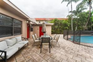 un patio con sofá, mesa y piscina en Spacious 5BR Home with Pool, Near Downtown & Beach, en Hollywood