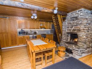 eine Küche mit Tisch und Steinkamin in der Unterkunft Holiday Home Kuusi-ruka 6 by Interhome in Rukatunturi 