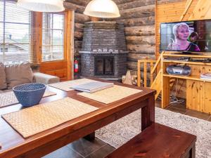 ein Wohnzimmer mit Tisch und Kamin in der Unterkunft Holiday Home Villa olivia by Interhome in Rukatunturi 