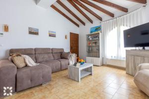 salon z kanapą i telewizorem z płaskim ekranem w obiekcie Villa Nani by Abahana Villas w mieście Calpe