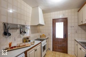 kuchnia z białymi kafelkami i białymi urządzeniami w obiekcie Villa Nani by Abahana Villas w mieście Calpe
