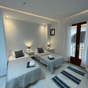 a bedroom with two beds with towels on them at Casa Florinda Tarifa in Tarifa