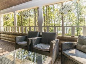 a screened in porch with chairs and a table at Holiday Home Villa kallahti beach view helsinki by Interhome in Helsinki